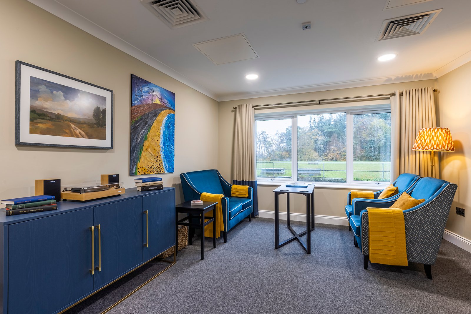 Moorhill Care Home lounge with coordinated blue and yellow seating, cabinet furniture and artwork